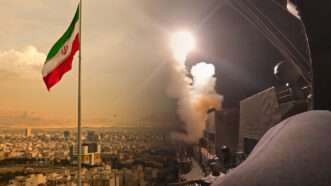 Composite picture of the Iranian flag and of missiles being fired from a warship | Borna Mirahmadian/Dreamsime/U.S. Central Command