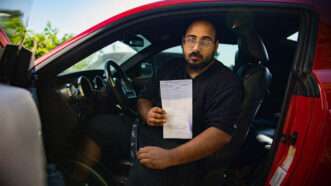 Mario Rosales sits in his car while holding up a copy of the citation he received in June 2022 | Institute for Justice