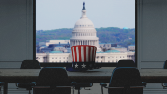 An Uncle Sam hat on a conference table in front of an image of the U.S. Capitol | Songquan Deng/Dreamstime/Who is Danny/Magnific/Designer191/Magnific AI/Mariam Zakaidze