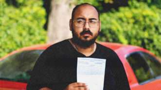 Mario Rosales holds a citation he received after a traffic stop in Alexandria, Louisiana | Institute for Justice