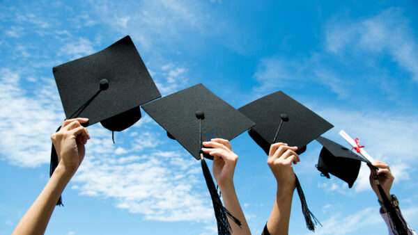Graduation caps are held in the air with the sky in the background | Photo 32533865 © Hxdbzxy | Dreamstime.com