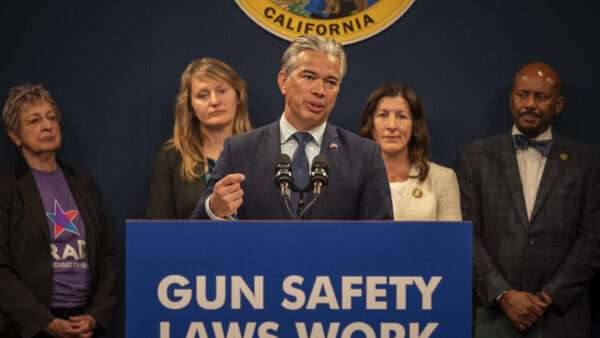 California Attorney General Rob Bonta speaking at a podium, flanked by two people each on his right and left, all standing beneath California's state seal. | Renée C. Byer/ZUMAPRESS/Newscom