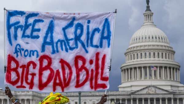 A protestor holds up a sign that says "Free American from Big Bad Bill" | Eric Kayne/ZUMAPRESS/Newscom