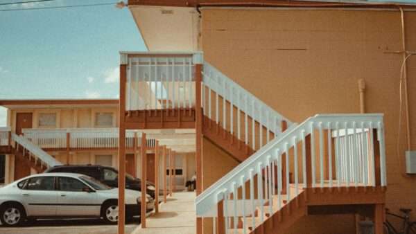 Motel | Photo by <a href="https://unsplash.com/@caviking101?utm_content=creditCopyText&utm_medium=referral&utm_source=unsplash">Andrew Karn</a> on <a href="https://unsplash.com/photos/two-vehicles-parked-in-front-of-establishment--yZjegM0sUw?utm_content=creditCopyText&utm_medium=referral&utm_source=unsplash">Unsplash</a>       