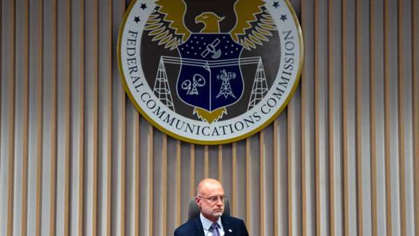 Brendan Carr sitting beneath the FCC seal | Photo: Federal Communications Commission Chairman Brendan Carr; Kent Nishimura/Bloomberg/Getty