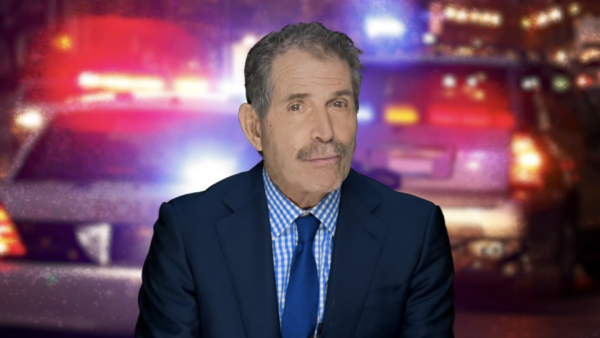 John Stossel stands in front of police cruisers | Stossel TV