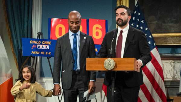 New York Mayor Zohran Mamdani speaks at an event in front of a "Child Care for All" placard. | Derek French/ZUMAPRESS/Newscom