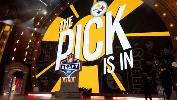 A giant screen with a yellow and black background and the Pittsburgh Steelers logo says "THE PICK IS IN," behind a lectern with a logo that says "NFL DRAFT 2024 DETROIT." | Photo: John Smolek/Icon Sportswire EDG/John Smolek/Icon Sportswire/Newscom