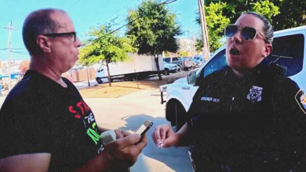 Video screenshot showing a police officer and a preacher | Illustration: truefaithamerica/Facebook