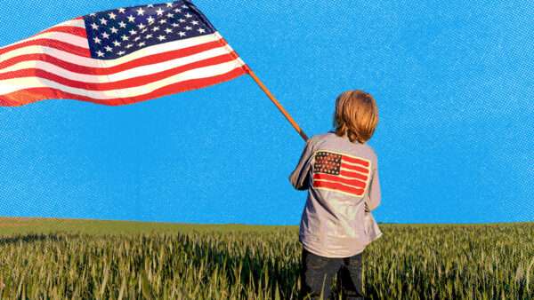 Young kid waving an American flag in a field | Envato