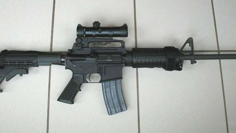 AR-15 laying against white planks | Stag1500/Wikimedia