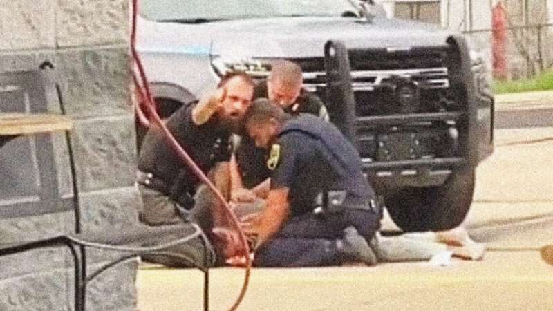 Three Arkansas police officers hold down and pummel a man outside a convenience store.