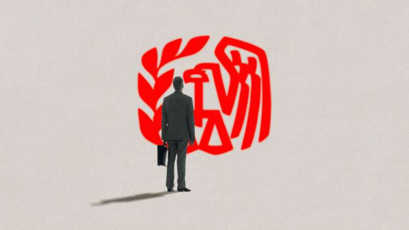 Man in suit stands in front of red logo on a tan background