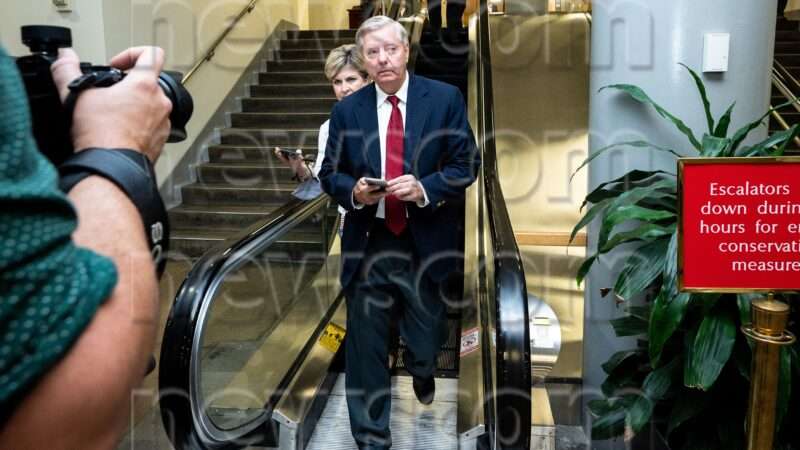 Lindsey Graham walks with reporters