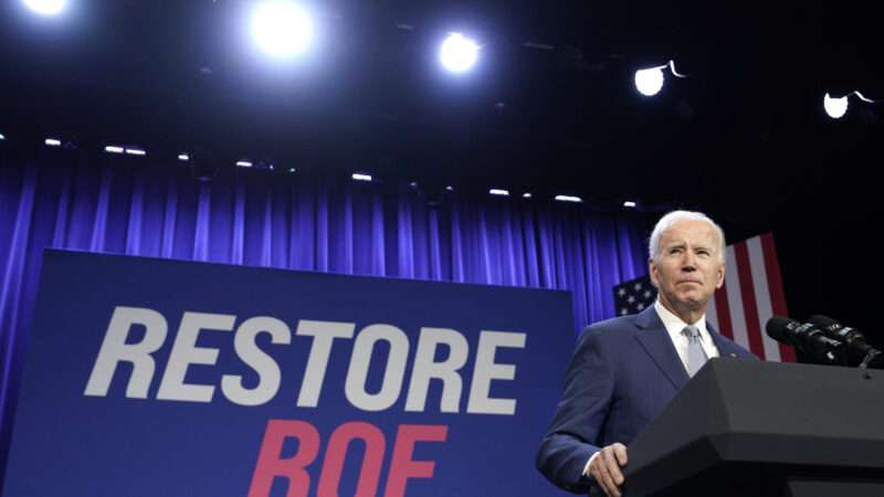 Joe Biden in front of a sign that says "Restore Roe" | CNP/AdMedia/Newscom