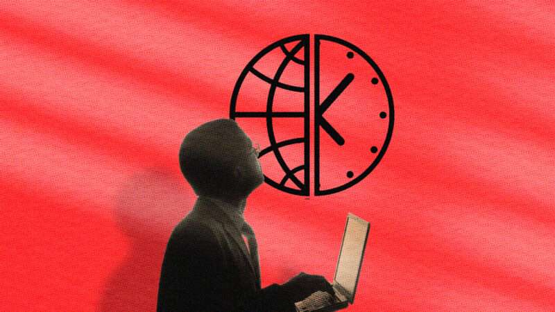 A man works on a computer against a red background and a clock