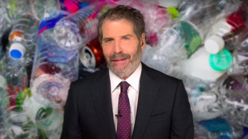 John Stossel is seen in front of a pile of plastic water bottles