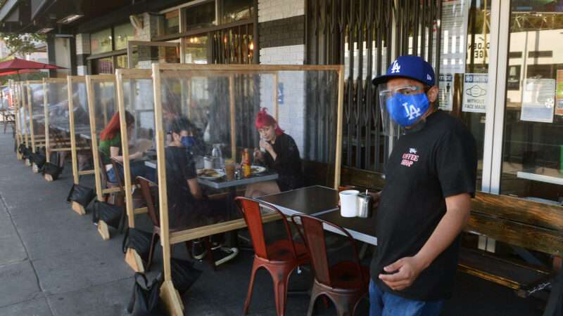 Diners eating outside in Los Angeles separated by plastic walls