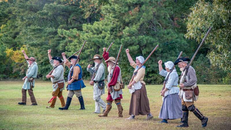 American Revolution-era war reenactors cheer. | Carrie Hanrahan | Dreamstime.com