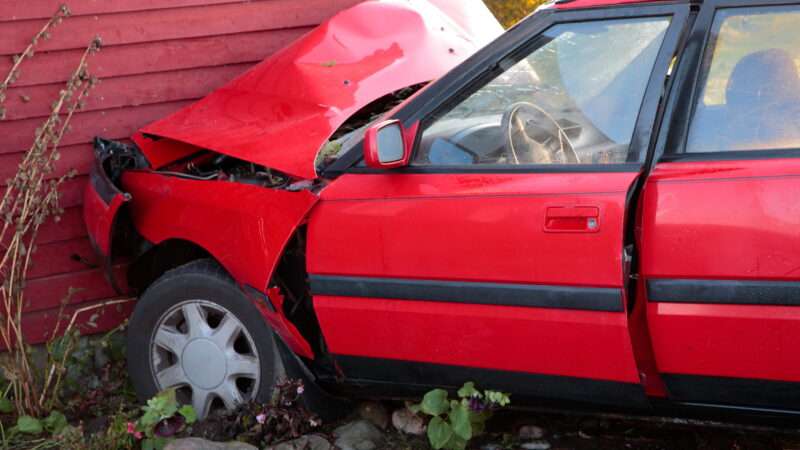 A car crashed into the side of a structure.