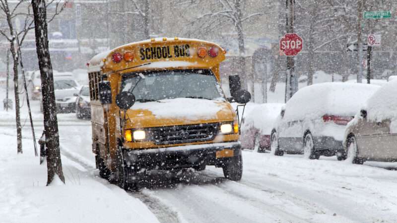 A yellow school bus on a snowy street.