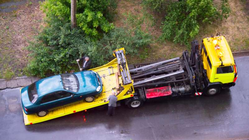 Overhead shot of a car being loaded onto a tow truck.