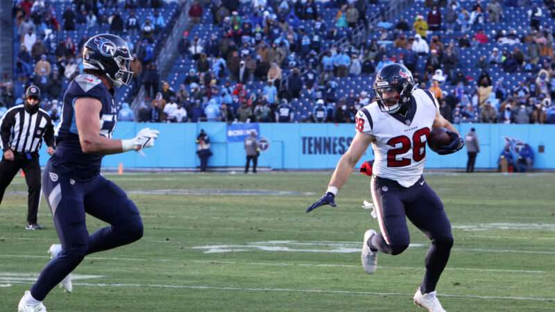 A Houston Texans player runs with the football, trying to evade a Tennessee Titans player. | Matthew Maxey/Icon Sportswire DHH/Matthew Maxey/Icon Sportswire/Newscom