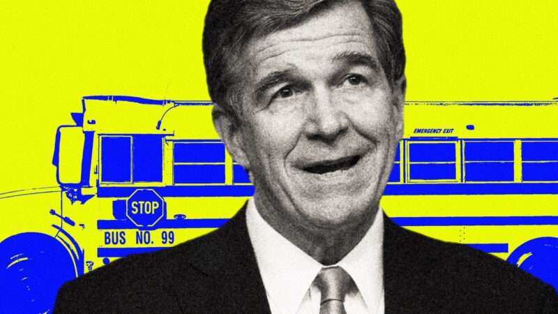 North Carolina Gov. Roy Cooper in front of a school bus.