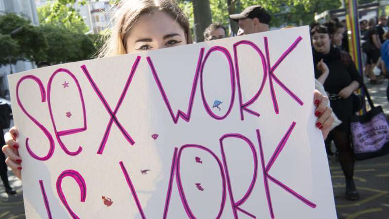 "Sex Work is Work" sign being held by a protester in Berlin | Paul Zinken/dpa/picture-alliance/Newscom
