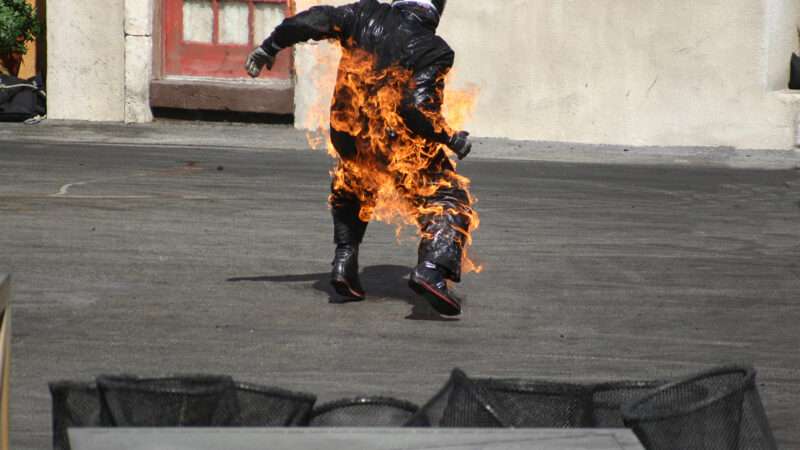 Man in motorcycle gear on fire
