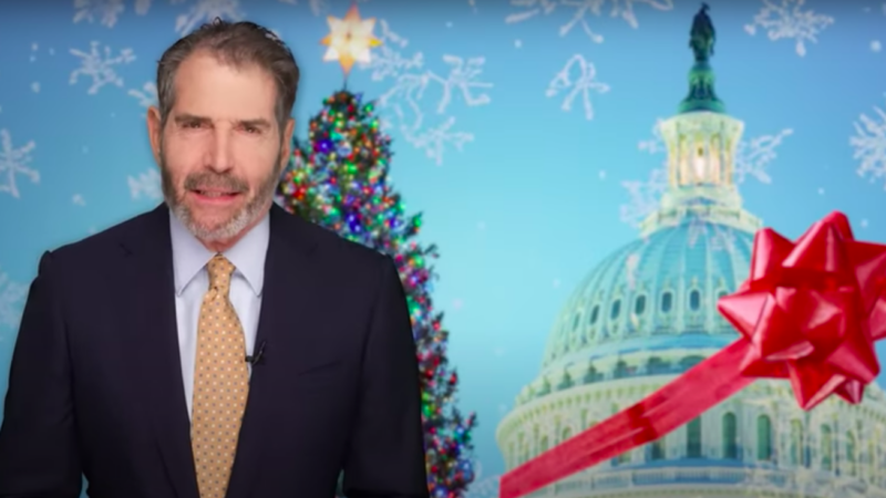 John Stossel is seen in front of a Christmas tree and the U.S. Capitol