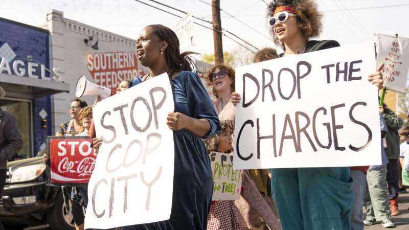 Anti-"Cop City" protesters hold signs that say STOP COP CITY and DROP THE CHARGES | Steve Eberhardt/ZUMAPRESS/Newscom