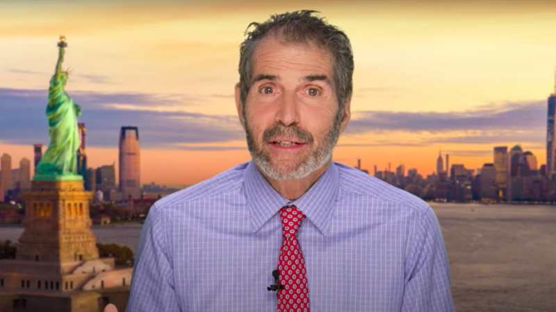 John Stossel is seen in front of the New York City skyline and Statue of Liberty