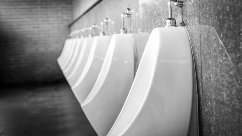 Black-and-white image of a row of urinals in a public men's room. | Artinun Prekmoung | Dreamstime.com