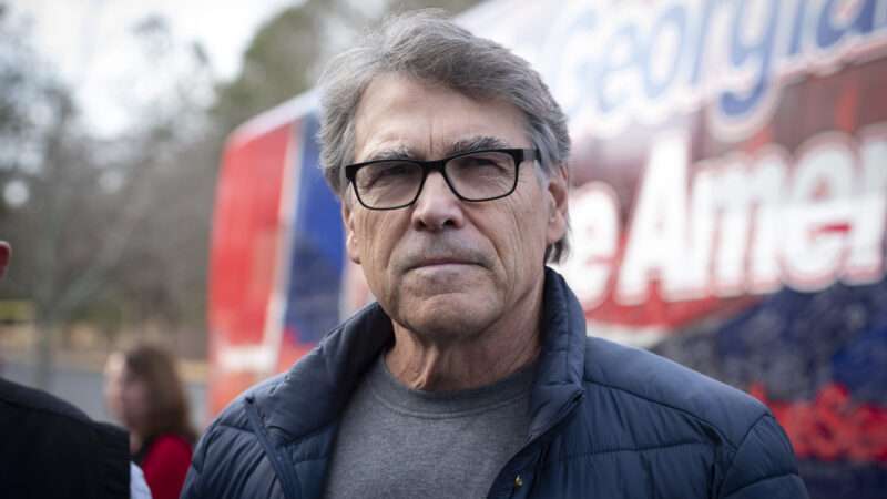 Rick Perry standing in front of a campaign bus | Robin Rayne/ZUMAPRESS/Newscom