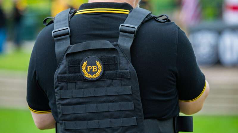 A member of the Proud Boys wears a tactical vest with the group's insignia on the back. | Gaspard Le Dem/Sipa USA/Newscom