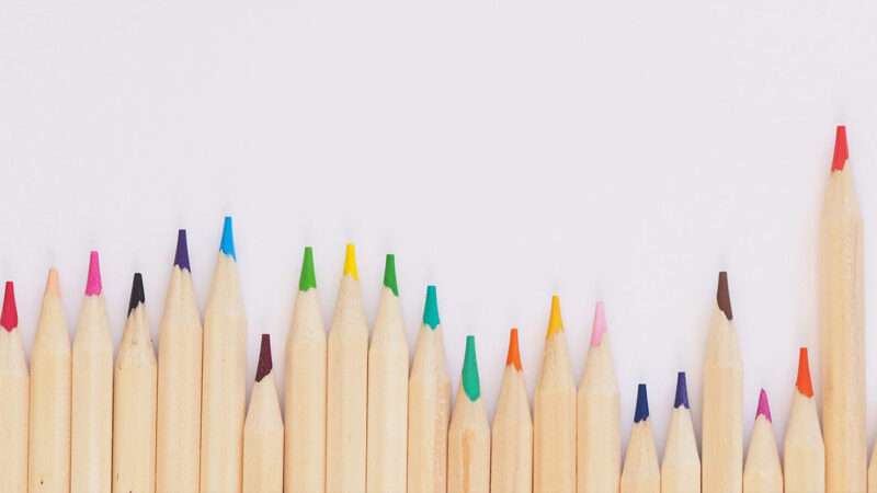 colored pencils in an uneven row against a white background | Photo: Jess Bailey/Unsplash