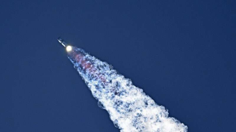 A SpaceX rocket flies across the frame from right to left, with engines bright at the bottom of the rocket, and smoke flying out of the bottom. | JOE MARINO/UPI/Newscom