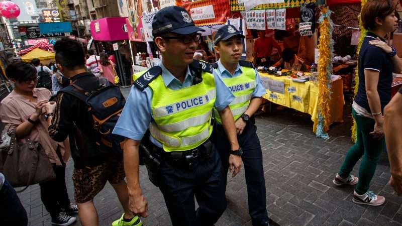 Hong Kong police officers walk through a crowd during the Lan Kwai Fong Festival. | Sam D\'cruz | Dreamstime.com