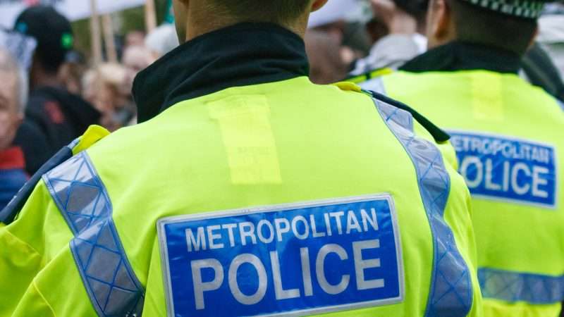 Two Metropolitan Police Officers in a crowd | Lawrence Willard | Dreamstime.com