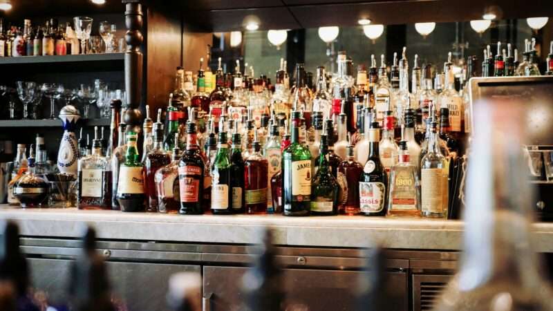 Liquor bottles behind a bar | Photo: Eaters Collective on Unsplash