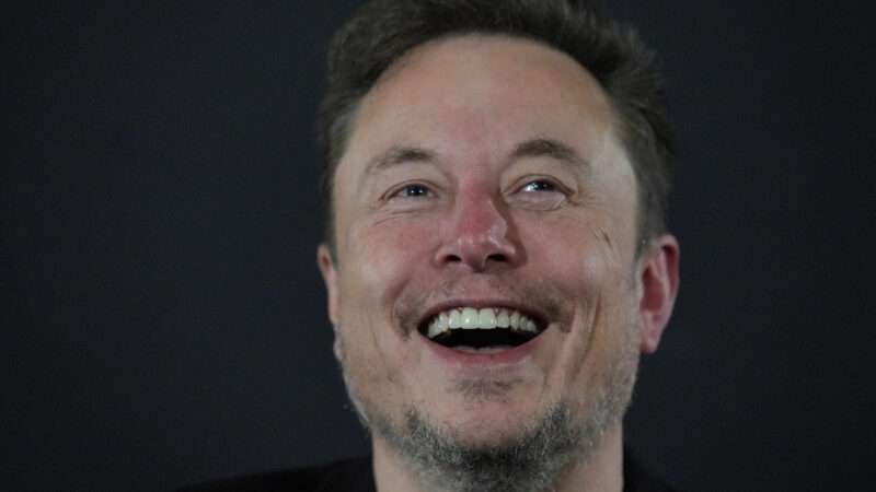 Elon Musk laughing against a dark background | Avalon/Newscom