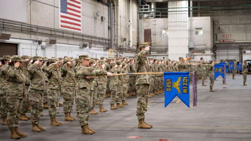 Military members saluting a flag | Air National Guard photo by Airman 1st Class Julia Ahaesy
