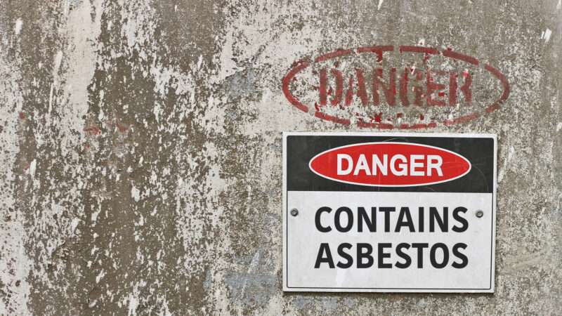 A sign on a wall that says DANGER: CONTAINS ASBESTOS | Kim Britten | Dreamstime.com