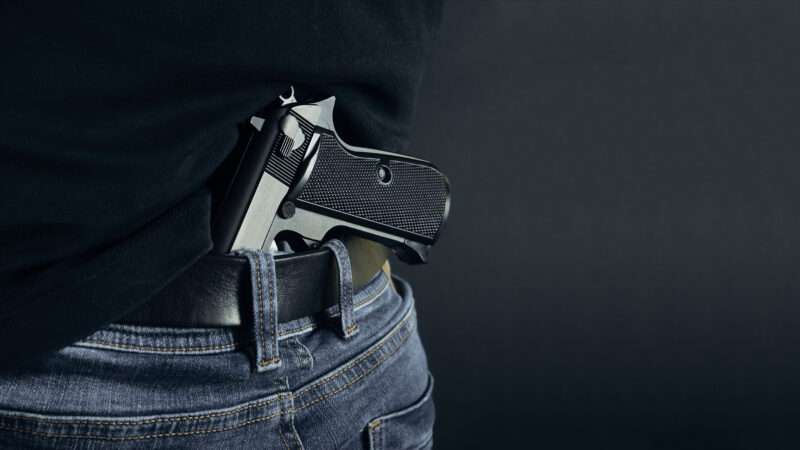 A pistol tucked into the back waistband of somebody's pants. | Artem Burduk | Dreamstime.com