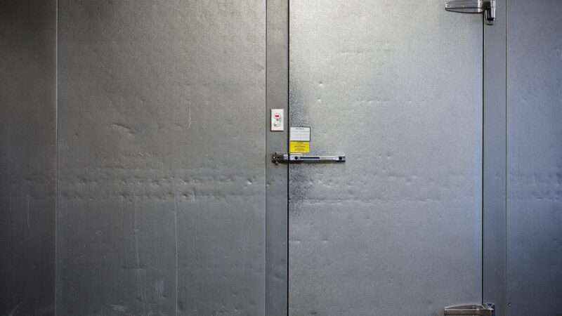 The locked door of a commercial freezer, seen from the outside. | Wellesenterprises | Dreamstime.com