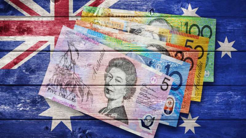 The Australian flag and Australian banknotes painted on a wooden background. | Cammeraydave | Dreamstime.com