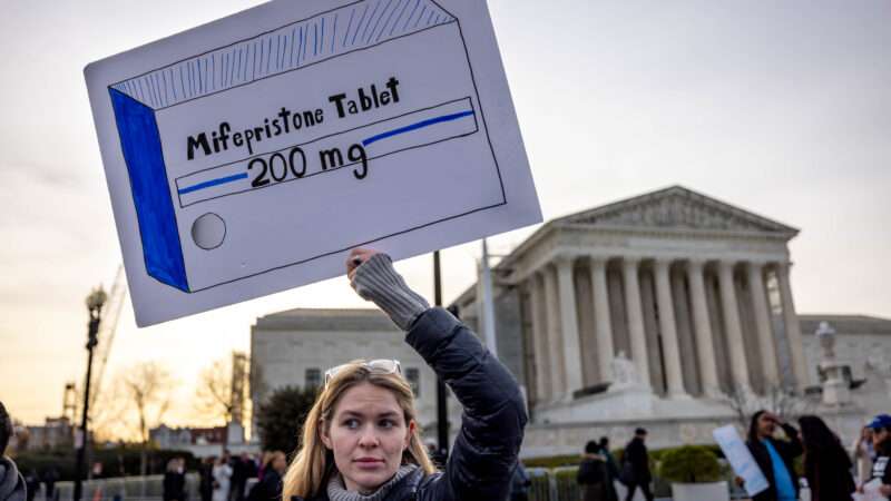 pro-choice protestor holding up a sign depicting an abortion drug | Michael Nigro/ZUMAPRESS/Newscom
