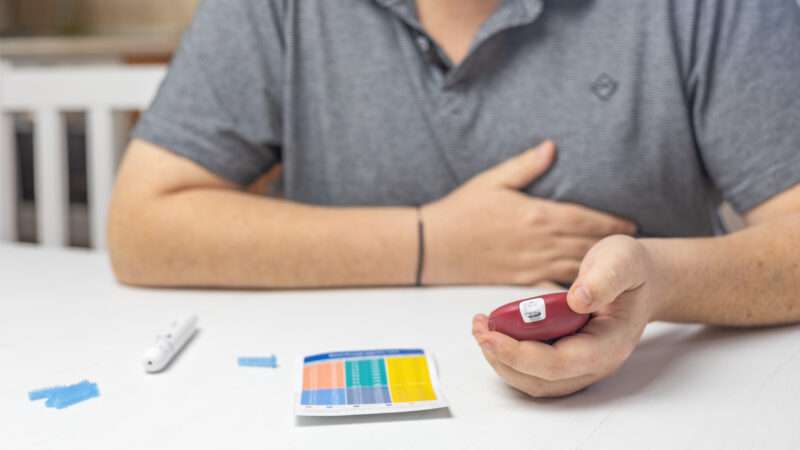 A man sits at a table using an at-home medical test | frank11/Newscom