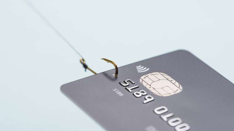 A credit card with a fishhook through it and fishing line, signifying a phishing attempt. | Nevodka | Dreamstime.com